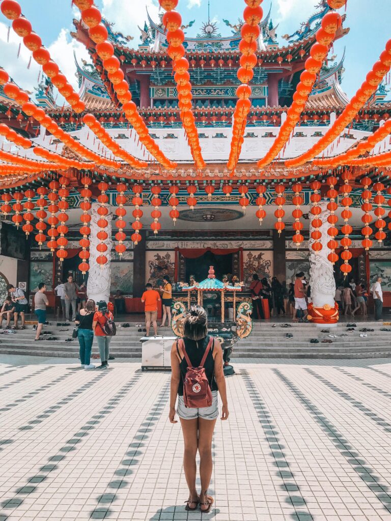 A woman stands amidst vibrant lanterns at Thean Hou Temple in Malaysia.