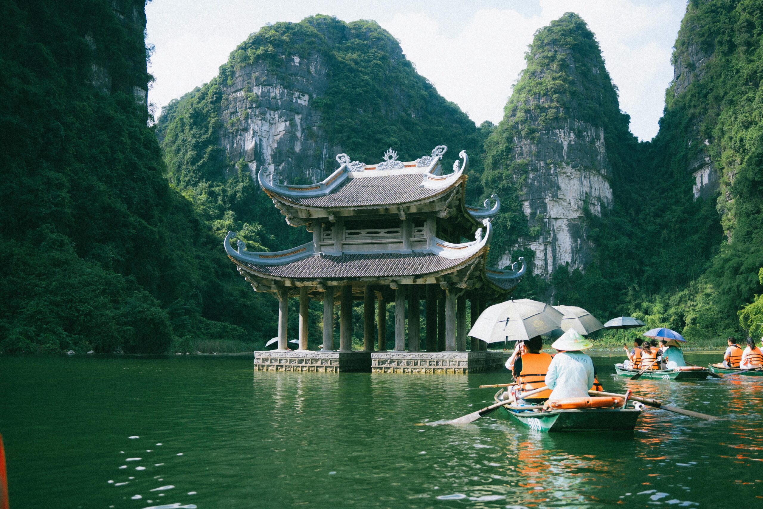 Explore the serene waters of Ninh Bình with lush karst landscapes and traditional architecture.